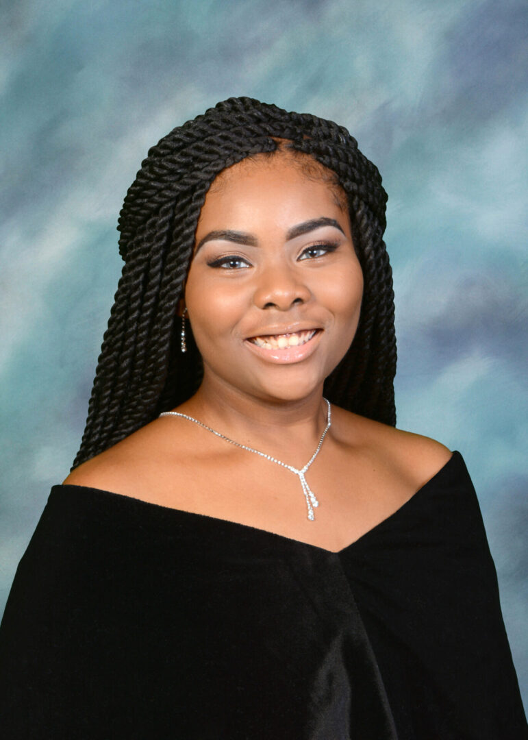 A Girl With Black Braids in a Black Graduation Robe