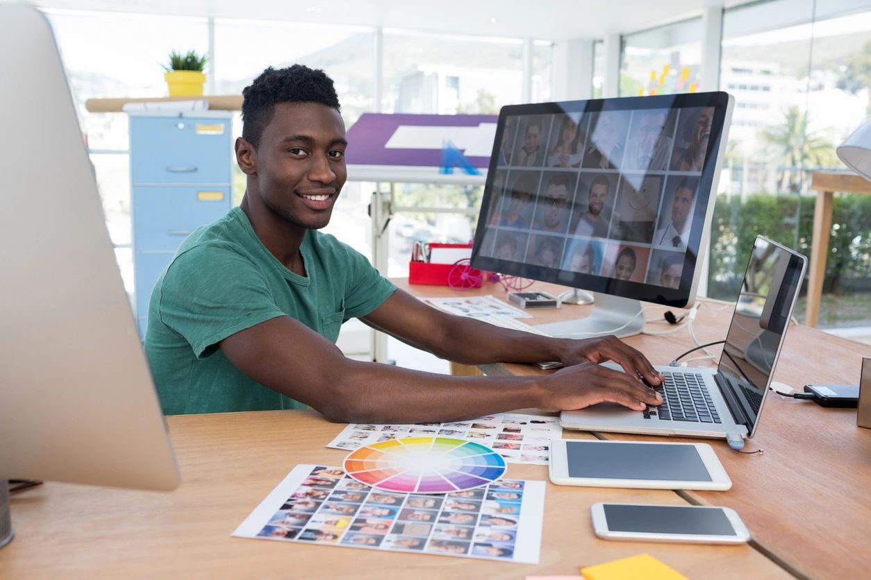 A man sitting at his desk with two computers.